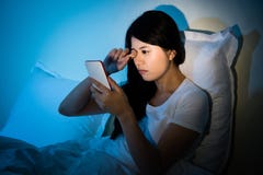 Lo sfregamento della donna osserva con per mezzo dello smartphone fotografie stock libere da diritti Lo sfregamento della donna osserva con per mezzo dello smartphone fotografie stock libere da diritti