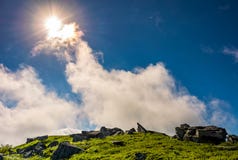 Lo sprazzo di sole su un cielo blu con si rannuvola le montagne Fotografie Stock Lo sprazzo di sole su un cielo blu con si rannuvola le montagne Fotografie Stock