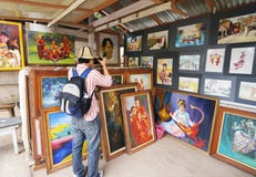 Lo straniero prende la foto su pittura nella manifestazione di arte fotografie stock Lo straniero prende la foto su pittura nella manifestazione di arte fotografie stock