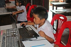 Lo studente asiatico sta usando il programma fotografie stock Lo studente asiatico sta usando il programma fotografie stock