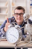 Lo studente e lo scheletro che preparano per gli esami della scuola Immagini Stock Libere da Diritti Lo studente e lo scheletro che preparano per gli esami della scuola Immagini Stock Libere da Diritti