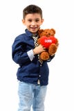 Lo studio ha sparato del ragazzo felice sveglio che sorride e che tiene lo spirito dell'orsacchiotto Fotografie Stock Libere da Diritti Lo studio ha sparato del ragazzo felice sveglio che sorride e che tiene lo spirito dell'orsacchiotto Fotografie Stock Libere da Diritti