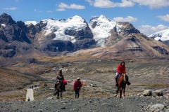 Locals riding horses to get up the high mountains, at Huascaran National Park, Peru.