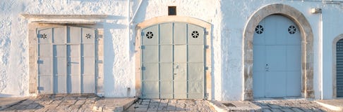 Locorotondo, Puglia, Itália do sul Foto panorâmico de três portas largas em cores pasteis foto de stock Locorotondo, Puglia, Itália do sul Foto panorâmico de três portas largas em cores pasteis foto de stock