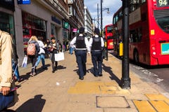 Oxford Street. Two unrecognizable police officers patrolling in the city. stock image Oxford Street. Two unrecognizable police officers patrolling in the city. stock image