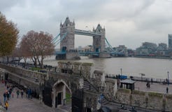 LONDRES, REINO UNIDO - 25 DE NOVEMBRO DE 2018: Parede da torre de Londres Com a ponte da torre no fundo foto de stock LONDRES, REINO UNIDO - 25 DE NOVEMBRO DE 2018: Parede da torre de Londres Com a ponte da torre no fundo foto de stock
