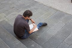 Lone man sitting on exterior steps reading a book Royalty Free Stock Photo Lone man sitting on exterior steps reading a book Royalty Free Stock Photo