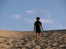 Lonely boy trekking in the dunes royalty free stock photos Lonely boy trekking in the dunes royalty free stock photos