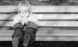 Lonely Child Sits On A Bench Royalty Free Stock Images