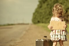 Lonely girl with suitcase standing about road