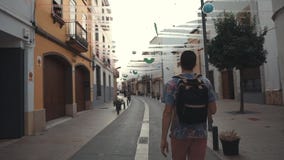 Lonely tourist is walking on ancient streets in small picturesque city in summer stock footage Lonely tourist is walking on ancient streets in small picturesque city in summer stock footage