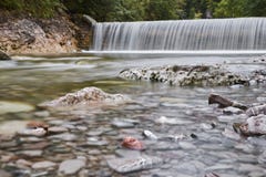 Long exposure of a waterfall with colorful stones in the foreground. stock images Long exposure of a waterfall with colorful stones in the foreground. stock images