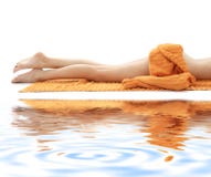Long legs of relaxed lady with orange towel on whi
