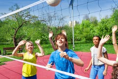 Los adolescentes están jugando a voleibol cerca de la red fotografía de archivo Los adolescentes están jugando a voleibol cerca de la red fotografía de archivo