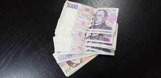 Los billetes de banco del coruna checo 1000 ponen en la tabla de madera negra foto de archivo libre de regalías Los billetes de banco del coruna checo 1000 ponen en la tabla de madera negra foto de archivo libre de regalías