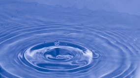 Los descensos del agua que golpean en superficie del agua crean ondas agradables en agua imagen de archivo libre de regalías Los descensos del agua que golpean en superficie del agua crean ondas agradables en agua imagen de archivo libre de regalías