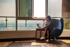 Los hombres de negocios femeninos est?n trabajando en los ordenadores y el caf? de consumici?n en la oficina fotos de archivo Los hombres de negocios femeninos est?n trabajando en los ordenadores y el caf? de consumici?n en la oficina fotos de archivo