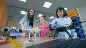 Los niños de la escuela exploran los abejones, helicópteros en la clase de la tecnología metrajes Los niños de la escuela exploran los abejones, helicópteros en la clase de la tecnología metrajes