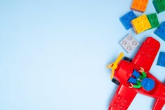 Los niños del bebé juegan el marco Ladrillos y avión multicolores de los cubos de la visión superior en fondo azul Los bloques po imagenes de archivo Los niños del bebé juegan el marco Ladrillos y avión multicolores de los cubos de la visión superior en fondo azul Los bloques po imagenes de archivo