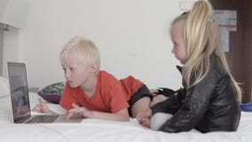 Los ni?os miran una historieta en el ordenador almacen de video Los ni?os miran una historieta en el ordenador almacen de video