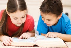 Los niños son libro de lectura foto de archivo Los niños son libro de lectura foto de archivo