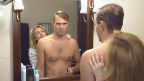 Los pares, el marido y la esposa recolectan en el cuarto de baño la esposa ya vestida está esperando a su marido que no ha recole almacen de metraje de vídeo Los pares, el marido y la esposa recolectan en el cuarto de baño la esposa ya vestida está esperando a su marido que no ha recole almacen de metraje de vídeo