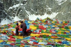 Los peregrinos tibetanos engendran y el hijo está colgando las banderas Lungta del rezo en paso del La de Drolma fotos de archivo libres de regalías Los peregrinos tibetanos engendran y el hijo está colgando las banderas Lungta del rezo en paso del La de Drolma fotos de archivo libres de regalías