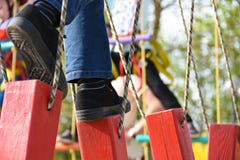 Los pies del paso del niño en la ejecución abren una sesión la carrera de obstáculos en el parque de atracciones, actividades al imagen de archivo Los pies del paso del niño en la ejecución abren una sesión la carrera de obstáculos en el parque de atracciones, actividades al imagen de archivo