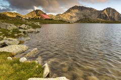 Los rayos pasados del sol sobre el lago y Kamenitsa Tevno enarbolan, montaña de Pirin fotos de archivo Los rayos pasados del sol sobre el lago y Kamenitsa Tevno enarbolan, montaña de Pirin fotos de archivo