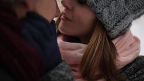 Los recienes casados preparan y el beso del abrazo de la novia y se calientan en bosque nevoso del pino durante las nevadas en la almacen de metraje de vídeo Los recienes casados preparan y el beso del abrazo de la novia y se calientan en bosque nevoso del pino durante las nevadas en la almacen de metraje de vídeo