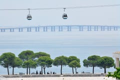 Los telef?ricos pasan por alto el puente de Vasco da Gama en el r?o Tagus fotografía de archivo Los telef?ricos pasan por alto el puente de Vasco da Gama en el r?o Tagus fotografía de archivo