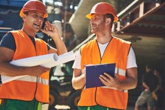 Los trabajadores en cascos están localizando en proyecto imagenes de archivo Los trabajadores en cascos están localizando en proyecto imagenes de archivo