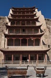 Los turistas en la entrada del Mogao excavan cerca de la ciudad de Dunhuang, en la provincia de Gansu, China imagen de archivo Los turistas en la entrada del Mogao excavan cerca de la ciudad de Dunhuang, en la provincia de Gansu, China imagen de archivo