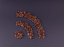 Los wi fi de la muestra presentaron los granos de café en un fondo oscuro fotos de archivo libres de regalías Los wi fi de la muestra presentaron los granos de café en un fondo oscuro fotos de archivo libres de regalías