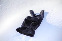 Lost black glove on the snow, close-up stock photography Lost black glove on the snow, close-up stock photography