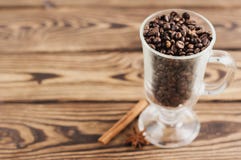 Lot of fried coffee beans in transparent glass for mulled wine with handle and leg near one anise and cinnamon stick stock images Lot of fried coffee beans in transparent glass for mulled wine with handle and leg near one anise and cinnamon stick stock images