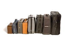 Lots of Travelling Suitcases. Big family's worth of various piled up travelling suitcases isolated on white Lots of Travelling Suitcases. Big family's worth of various piled up travelling suitcases isolated on white