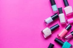 Lotto dello smalto delle bottiglie sulla vista superiore del fondo rosa fotografia stock Lotto dello smalto delle bottiglie sulla vista superiore del fondo rosa fotografia stock