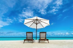 Lounger и зонтик пляжа на пляже песка Принципиальная схема для остальных, релаксации, праздников, спы, курорта Lounger и зонтик пляжа на пляже песка Принципиальная схема для остальных, релаксации, праздников, спы, курорта