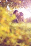 Love couple embrace under a tree in the autumn park stock image Love couple embrace under a tree in the autumn park stock image