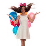 Lovely girl brunette with long hair in a white dress with a bow on her head and balloons posing on a white background Stock Images Lovely girl brunette with long hair in a white dress with a bow on her head and balloons posing on a white background Stock Images