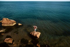 Lovely young adult couple on the rocks in the sea near the beach with big cliffs, Black Sea, Odessa, Ukraine, place for text set stock photos Lovely young adult couple on the rocks in the sea near the beach with big cliffs, Black Sea, Odessa, Ukraine, place for text set stock photos