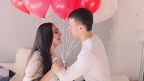 Loving couple on the bed with balloons stock video Loving couple on the bed with balloons stock video