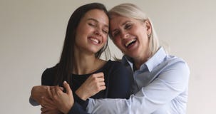 Loving happy older mature mom embracing young adult daughter, portrait