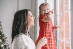 Loving mother playing with her baby girl looking at the window royalty free stock images Loving mother playing with her baby girl looking at the window royalty free stock images