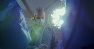 Low angle view of Caucasian male surgeon performing operation in operation theater at hospital stock footage Low angle view of Caucasian male surgeon performing operation in operation theater at hospital stock footage