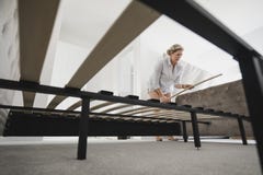 Mature Woman Building Bed in New Home Stock Image Mature Woman Building Bed in New Home Stock Image