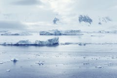 Low clouds over the mountains and chunks of ice floating of Port Lockroy research station Royalty Free Stock Images Low clouds over the mountains and chunks of ice floating of Port Lockroy research station Royalty Free Stock Images