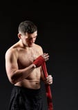 Low key studio portrait of handsome muscular fighter practicing boxing on dark blurred background stock photo Low key studio portrait of handsome muscular fighter practicing boxing on dark blurred background stock photo