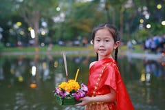 Loy Krathong festival, Asian Child girl in Thai traditional dress with holding krathong for forgiveness Goddess Ganges to stock photo Loy Krathong festival, Asian Child girl in Thai traditional dress with holding krathong for forgiveness Goddess Ganges to stock photo